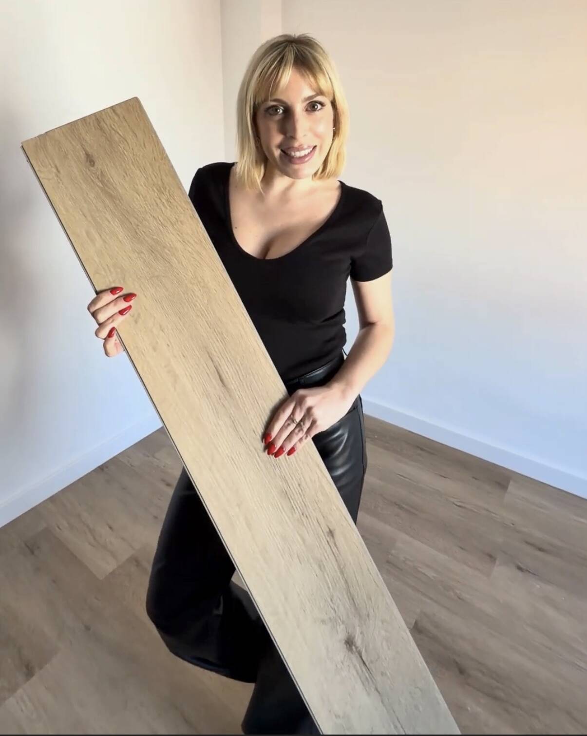 Profesional de reformas en Castellón mostrando una lama de suelo SPC imitación madera en vivienda reformada