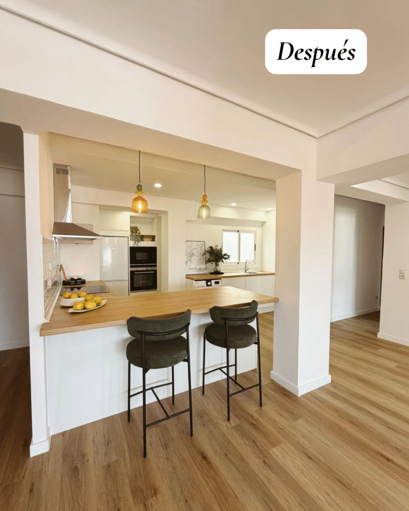 Cocina reformada con muebles blancos, encimera efecto madera, suelo SPC y zona de lavado integrada