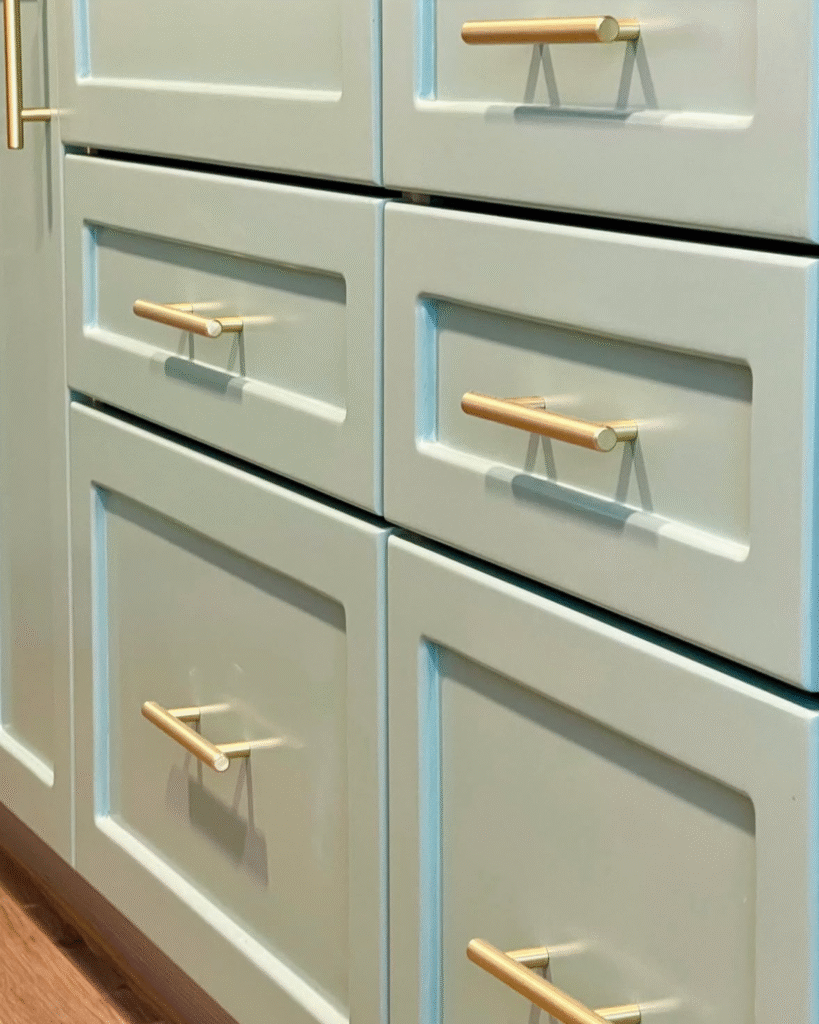 Detalles decorativos de una cocina reformada sin obra en Castellón, con cuadros, tazas, lámpara y acabados en tonos suaves.